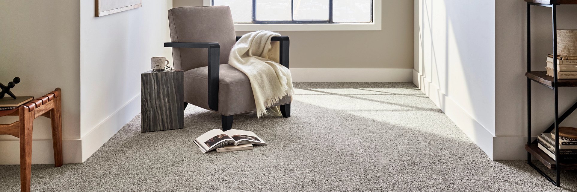 An armchair on a grey carpet having some books around it from Sams Floor Covering in Winchester, KY