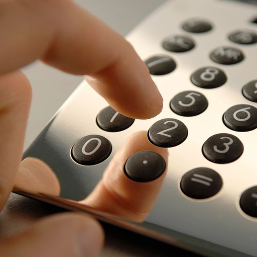 Hand typing on a desk calculator in Winchester, KY